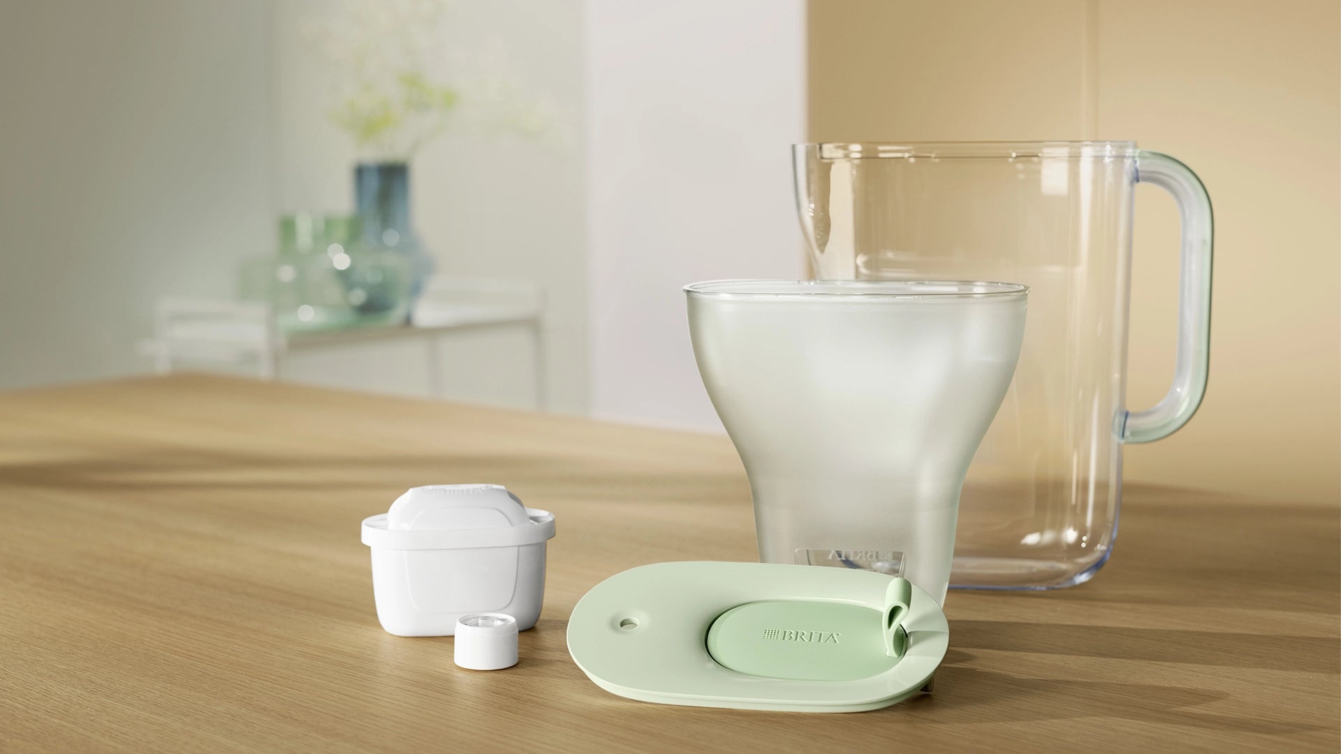 BRITA Style eco jug with green lid and a transparent base on a wooden surface.
