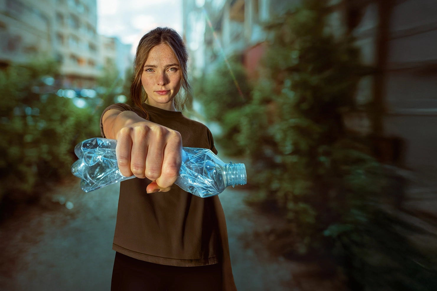 Person holding a plastic bottle in an urban setting