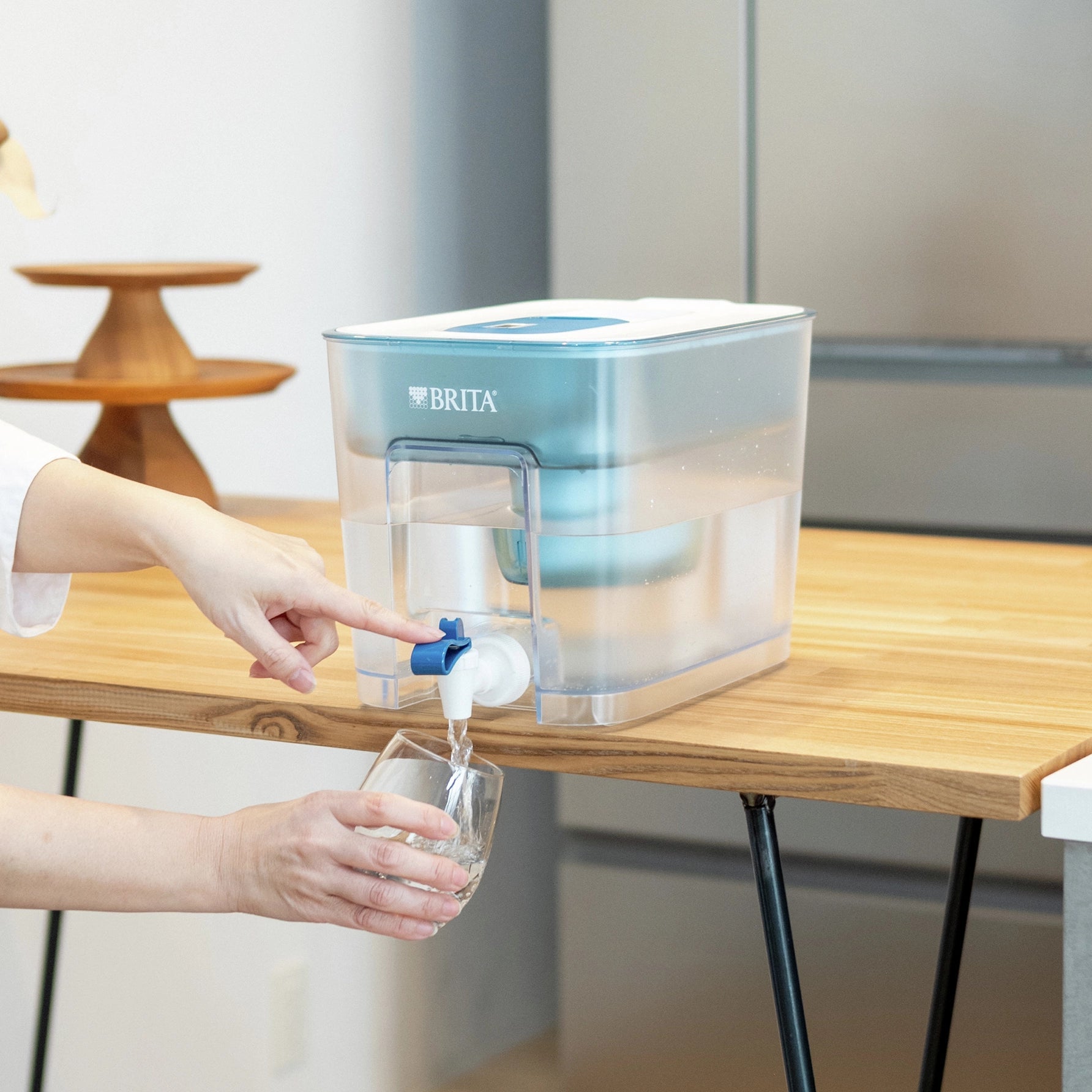 Una BRITA Flow con un MAXTRA PRO PURE PERFORMANCE se usa para llenar un vaso de agua