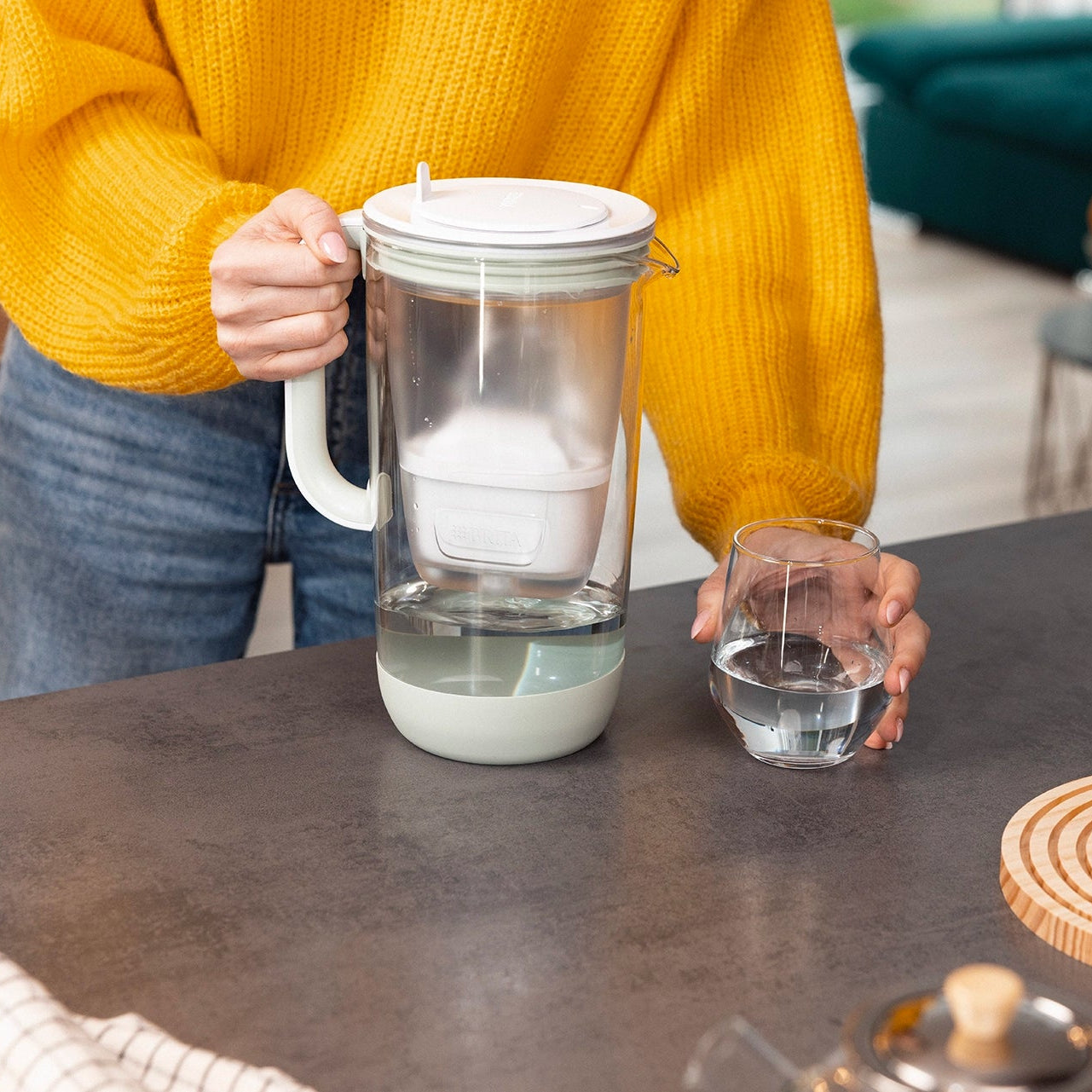 Green BRITA Glass Jug and a glass of filtered water on a kitchen counter.