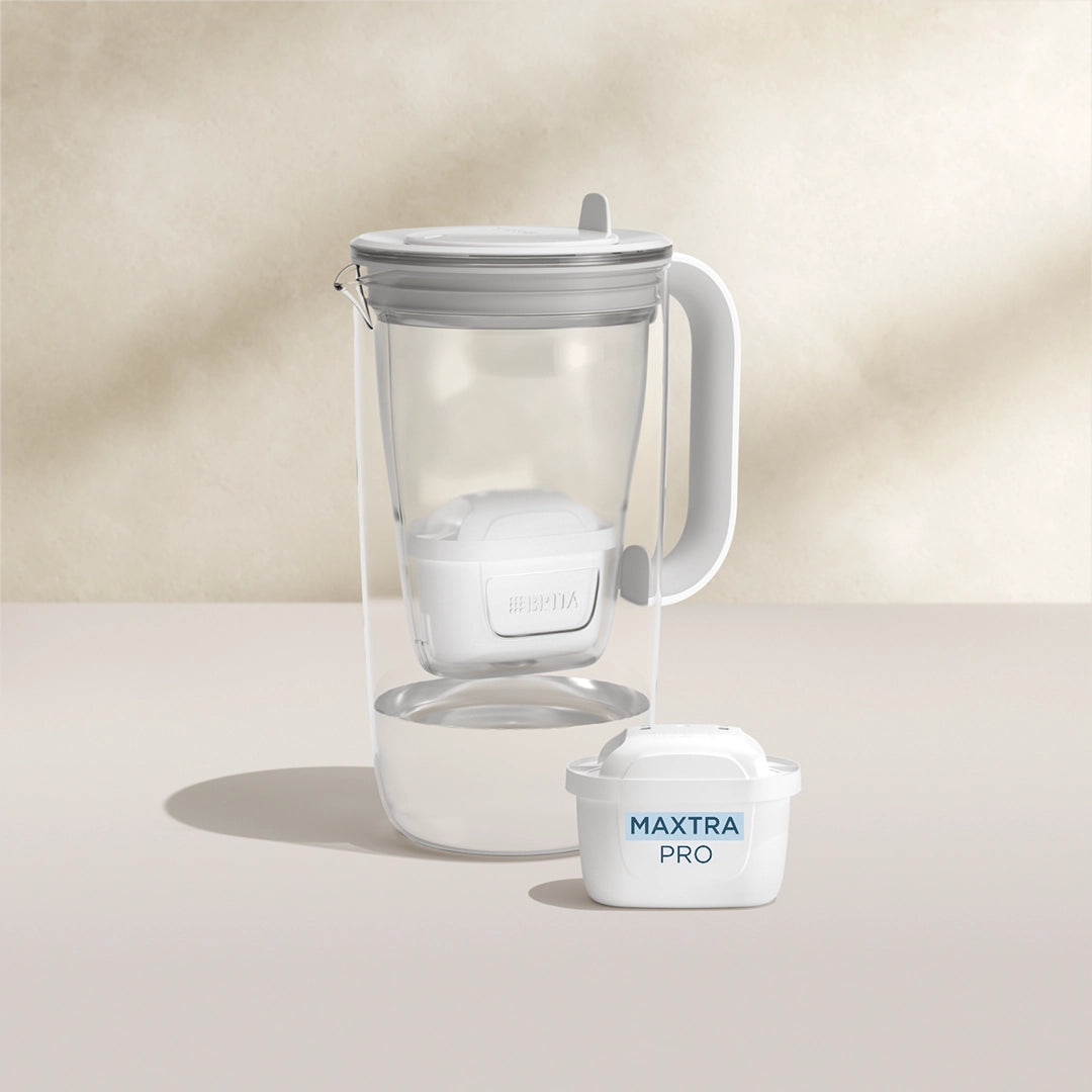 A water filter glass jug in grey on a beige background