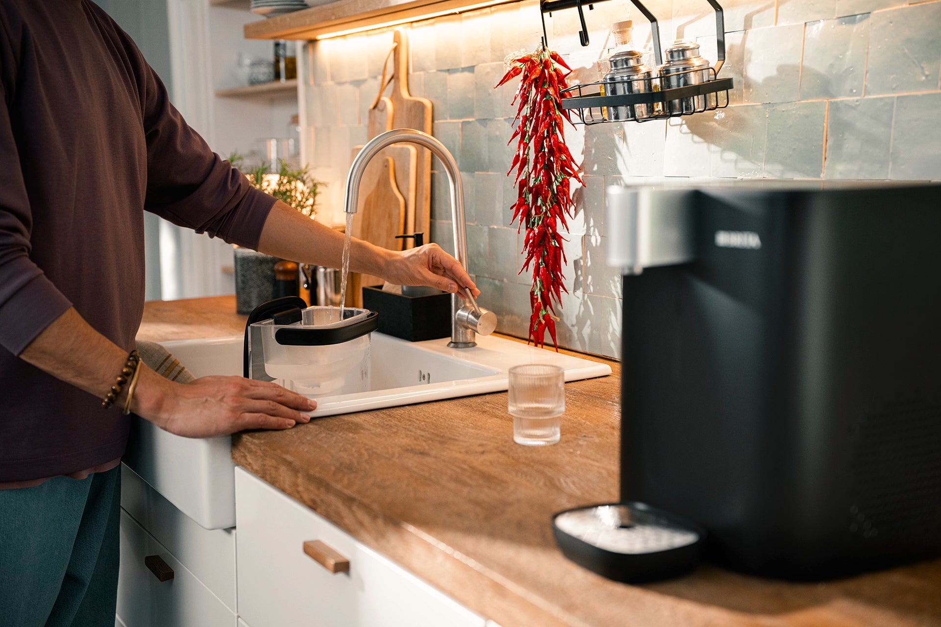 BRITA YOURCE cool water tank being refilled at a kitchen sink.